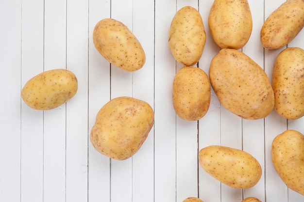 Raw potatoes on a white boards