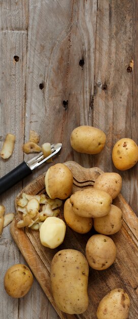 Raw potatoes with a vegetable peeler top view