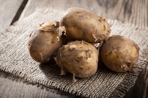 Raw potatoes on wooden table