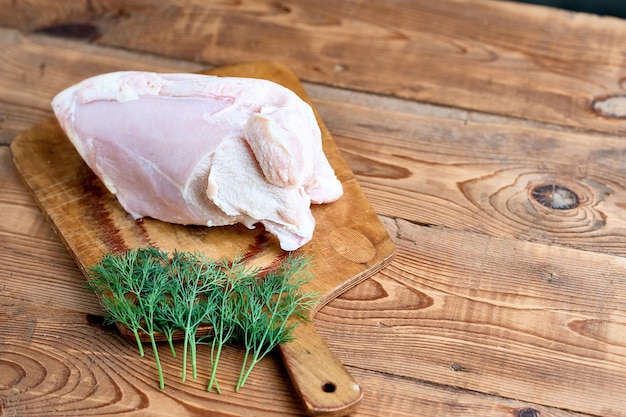 Photo raw poultry meat against the background of a tree