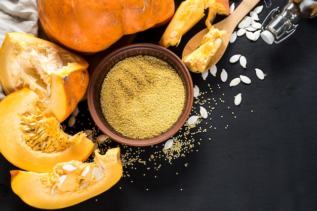 Foto semi di zucca e lenticchie crudi su fondo di legno nero. vista dall'alto. copia spazio