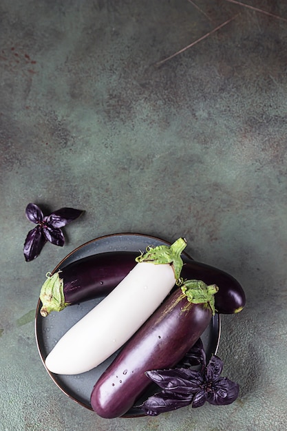 Raw purple and white eggplants with water drops