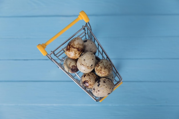 Raw quail eggs in mini shopping cart