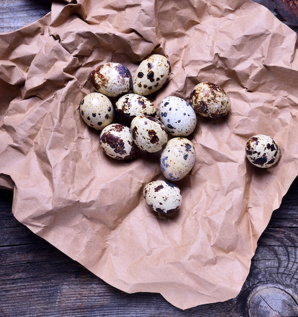 Raw quail eggs in shell on brown paper