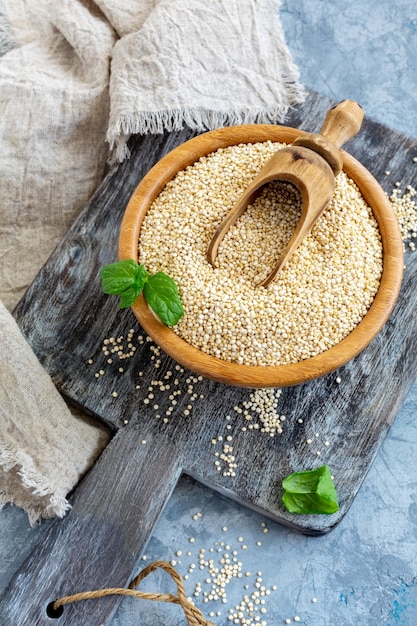 Raw quinoa seeds in the wooden bowl