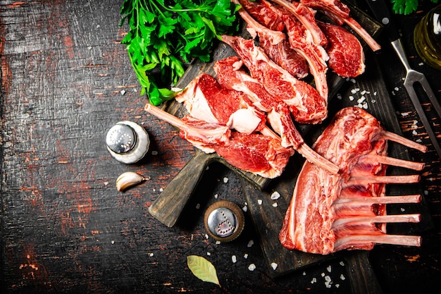 Raw rack of lamb with parsley on a cutting board