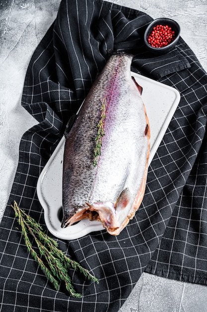 Raw rainbow trout fish with salt and thyme. Top view