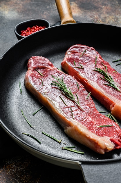 Raw ramp steak, fresh meat, marbled beef. Dark wall. Flat lay