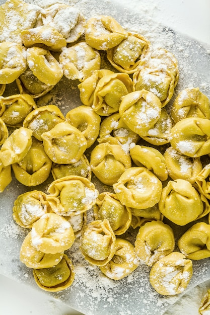 Foto tortellini di ravioli crudi sul tavolo con farina