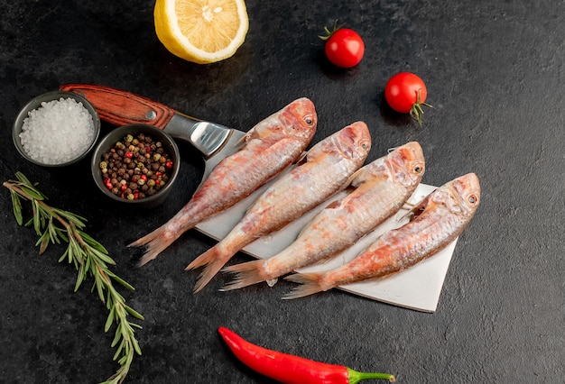 raw red mullet fish on stone background