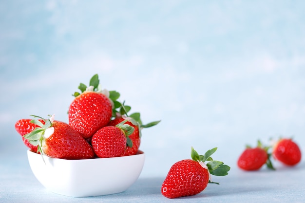 Raw Red Organic Strawberries in a Bunch on blue background.