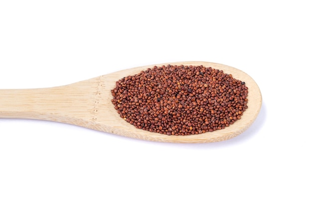 Raw red quinoa grains in a spoon isolated over white background