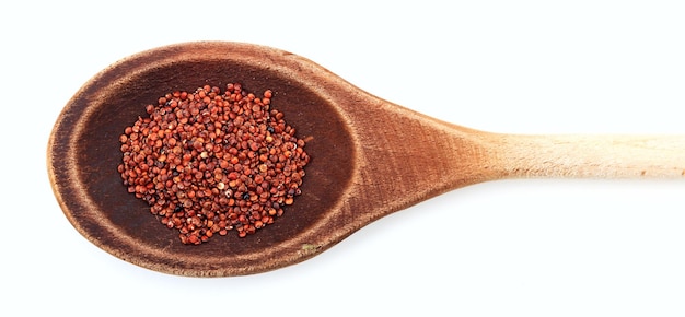 Raw red quinoa in a wooden spoon