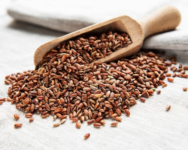 Raw red rice on a old textile background