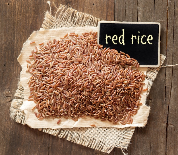 Photo raw red rice with a chalkboard on a wooden table