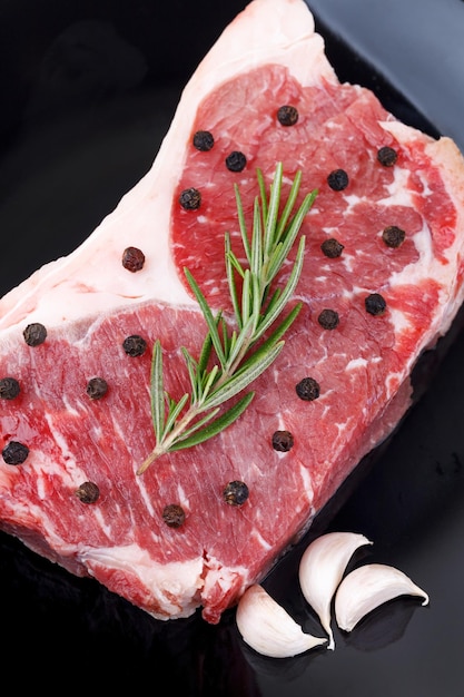 Raw red sirloin steak with rosemary garlic pepper