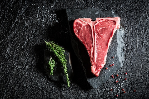 Raw red steak with salt pepper and rosemary