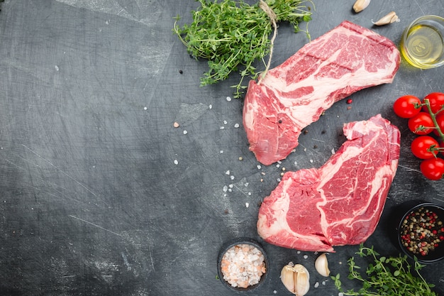 Photo raw rib eye beef steak on stone table