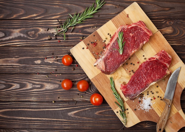 Raw ribeye beef steak cooking with ingredients. Top view with copy space