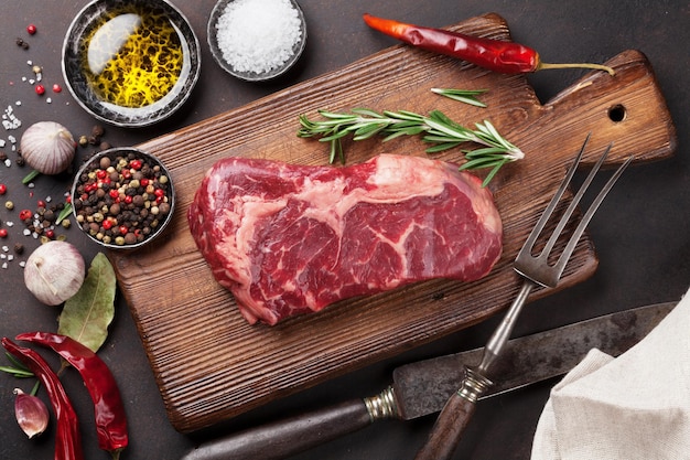 Raw ribeye beef steak cooking with ingredients