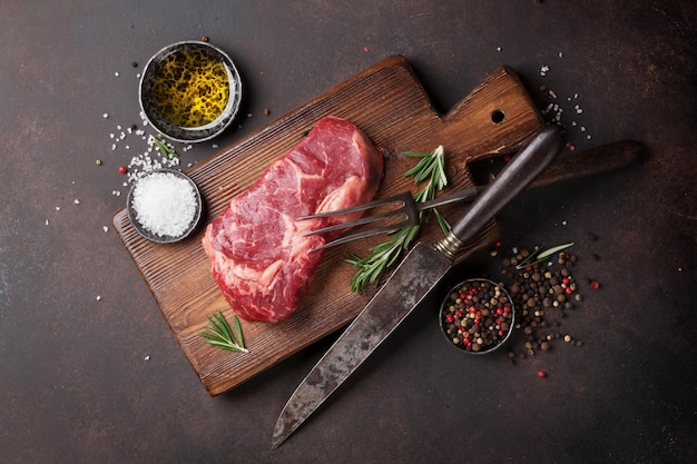 Raw ribeye beef steak cooking with ingredients