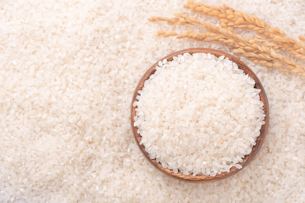 Raw rice in a bowl and full frame in the white background table top view overhead shot close up