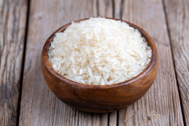 Raw rice on the wooden background