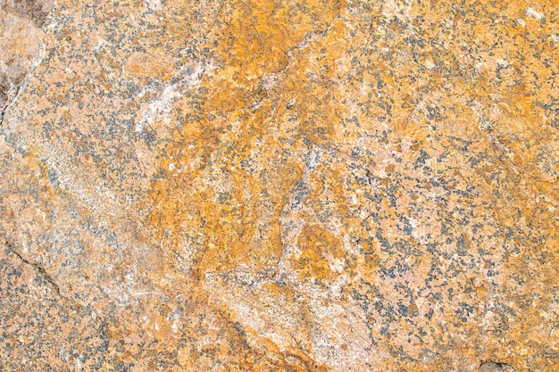 Raw rough yellow golden brown granite texture background. Natural rock stone texture background. Granite Grades. Muscovite colored minerals in granite