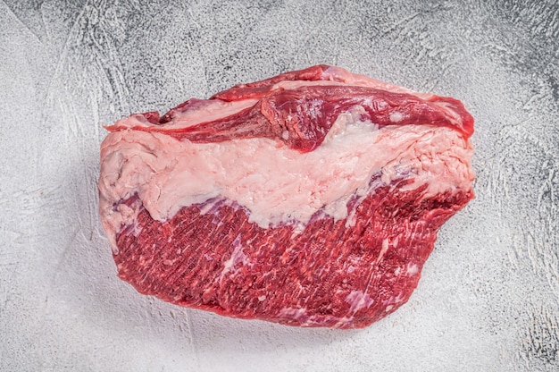 Raw Round beef meat cut on a butcher table. White background. Top view.