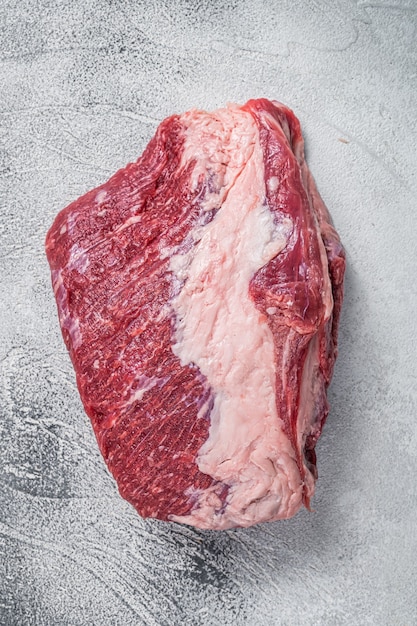 Raw Round beef meat cut on a butcher table. White