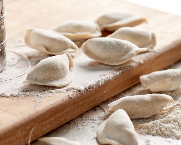 Raw russian dumplings with flour on table