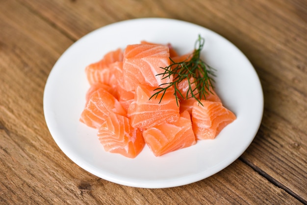 Foto cubetto di filetto di salmone crudo con erbe e spezie / pesce salmone fresco