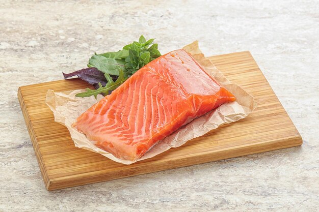 Raw salmon fillet over board