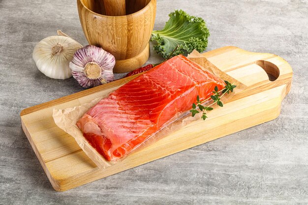 Raw salmon fillet piece over board