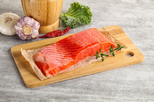 Raw salmon fillet piece over board