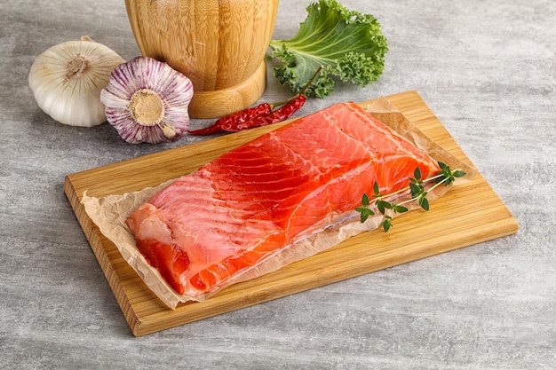 Raw salmon fillet piece over board