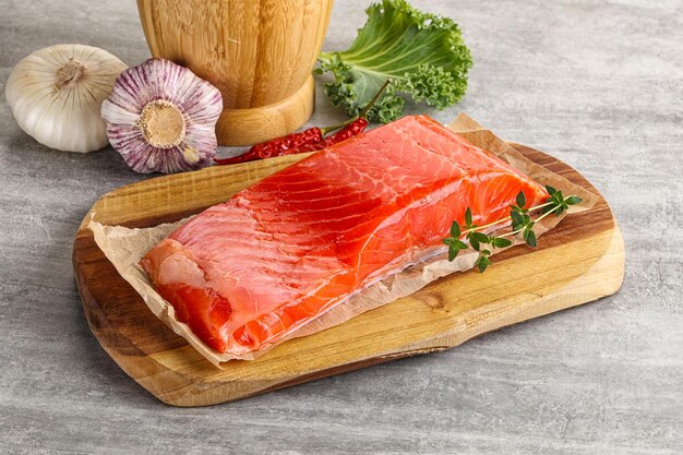 Raw salmon fillet piece over board