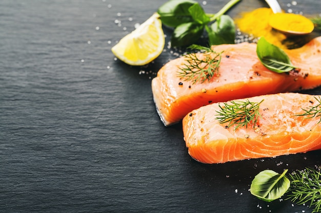 Foto pesce salmone crudo su ardesia nera