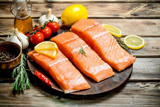 Raw salmon fish filet with lemon tomatoes and herbs