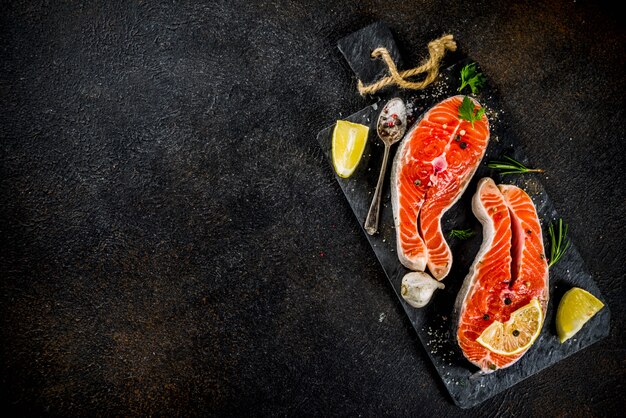 Raw salmon fish steaks with lemon, herbs, olive oil, ready for grill