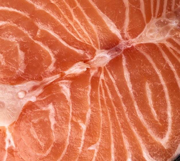 Photo raw salmon steak texture on black background top view close up