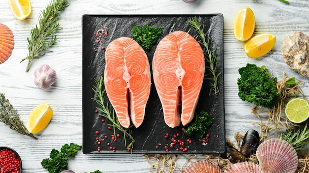 Raw salmon steak with spices On a white wooden background Top view