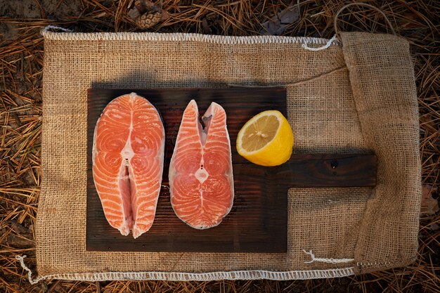 Raw salmon steaks and ingredients on a old wooden board