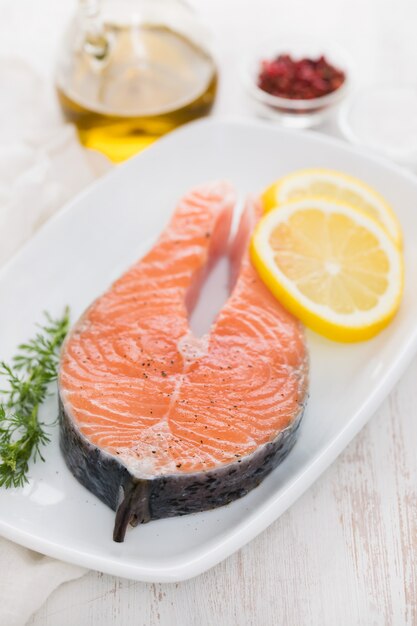 Raw salmon with lemon on white dish