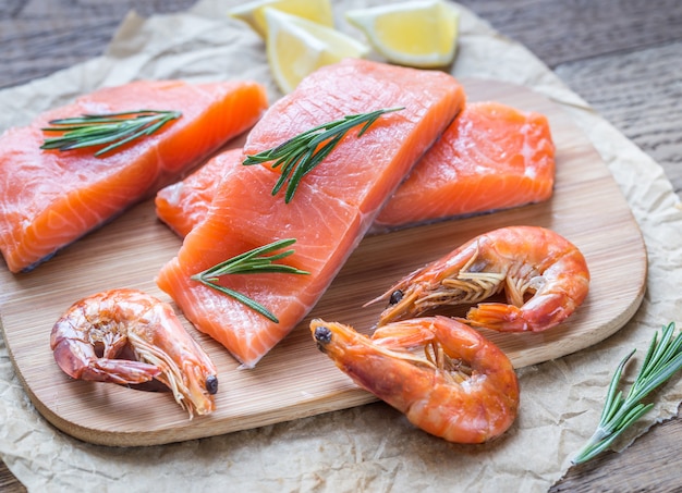 Raw salmon with shrimps on the wooden board