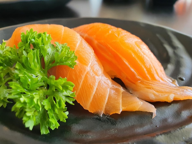 A raw salmonSalmon Sushi on a black plate