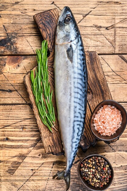 Raw saltwater fish Mackerel on a wooden cutting board with a thyme. 