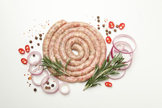 Raw sausage, herbs and spices on white table