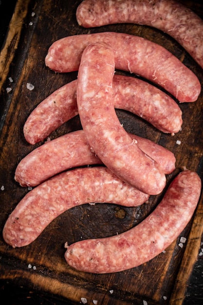 Raw sausages on a cutting board