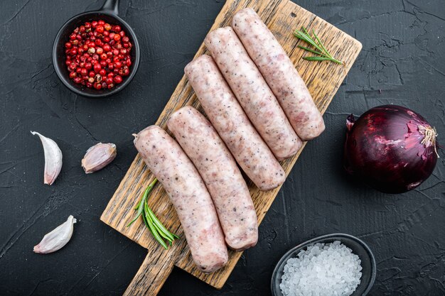 Raw sausages on dark background